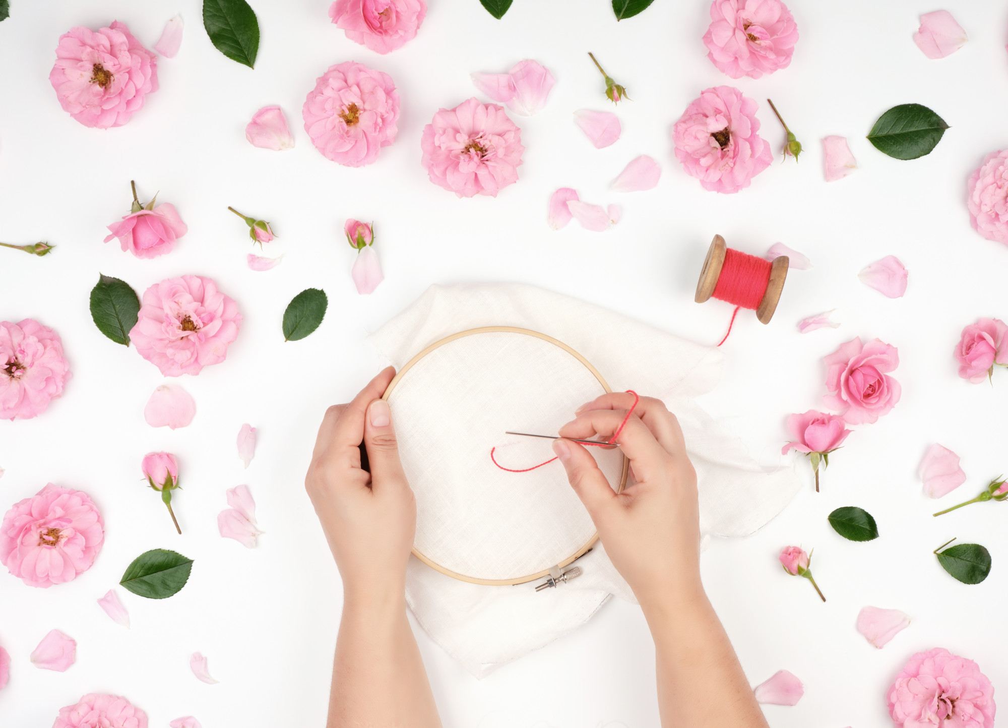 Close-up of hands doing traditional embroidery on linen